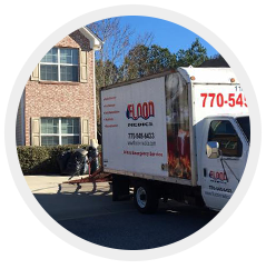 Moving truck unloading near residential home.